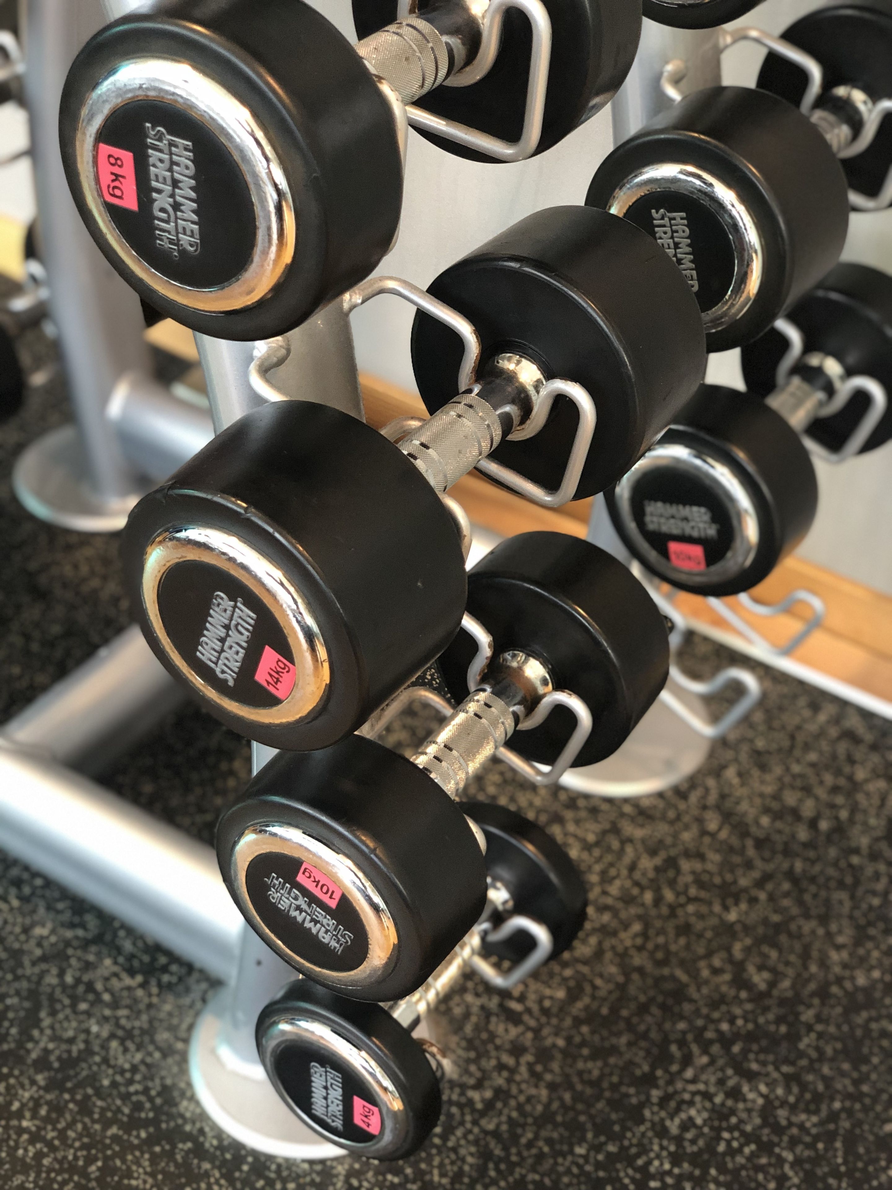 A rack of black dumbbells with weight labels.