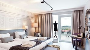 A hotel room with a large bed, a desk with a chair, a mannequin, and a view of the city through the window. - Scandic Rubinen (Gothenburg)