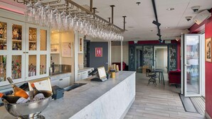 A bar area with a marble counter, bottles of champagne, and a wine cooler. - Scandic Rubinen (Gothenburg)