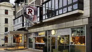 A restaurant with a modern facade, large windows, and outdoor seating. - Scandic Rubinen (Gothenburg)