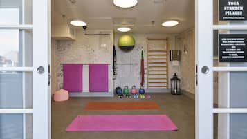 Un estudio de yoga con colchonetas, mancuernas y un saco de boxeo.