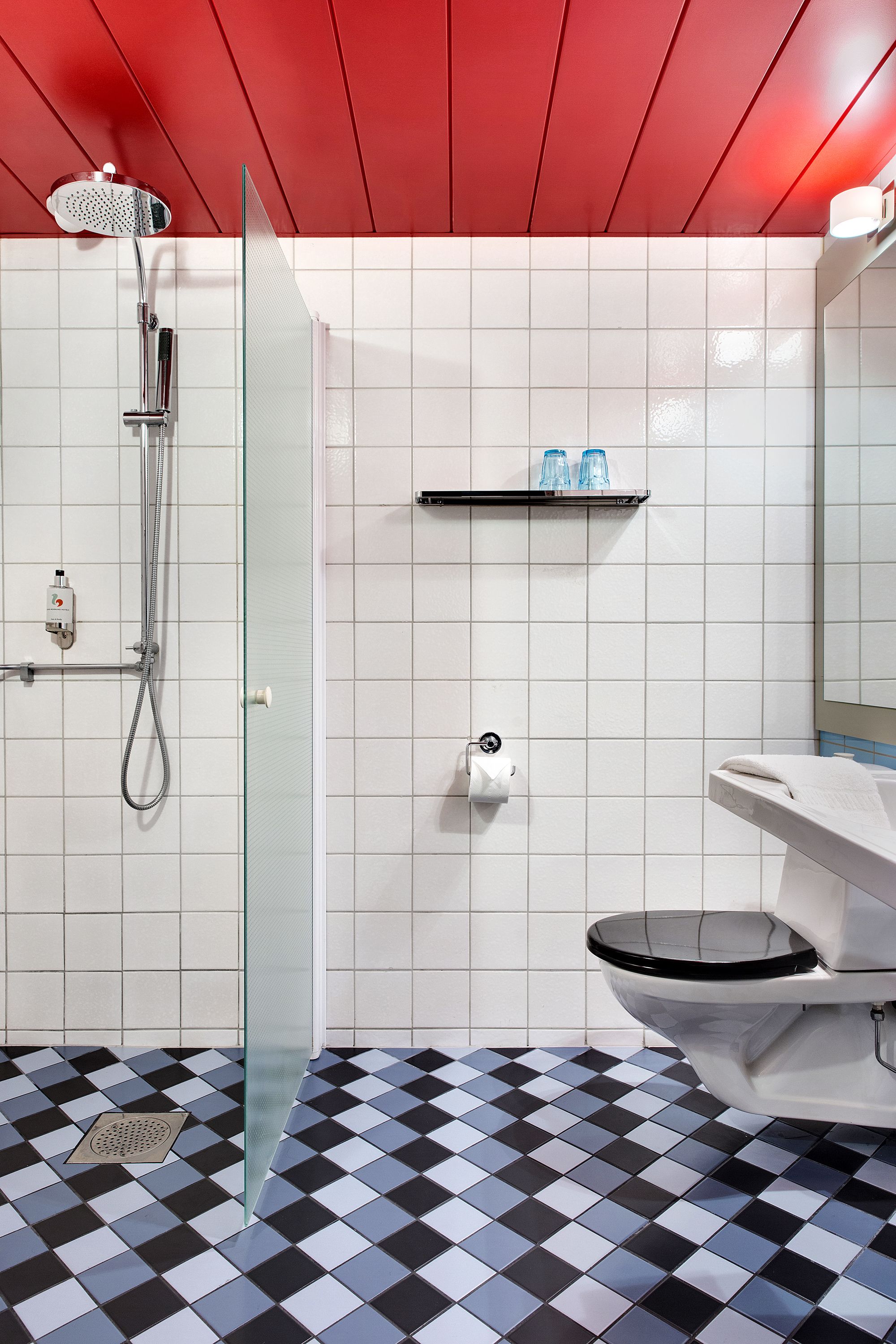 A bathroom with a glass shower enclosure, a toilet, and a sink.