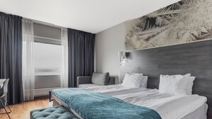 A modern hotel room with a bed, a desk, and a large window with curtains. - Quality Hotel Sundsvall (Sundsvall)