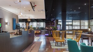 A modern hotel lobby with a reception desk, seating area, and large windows. - Quality Hotel Sundsvall (Sundsvall)