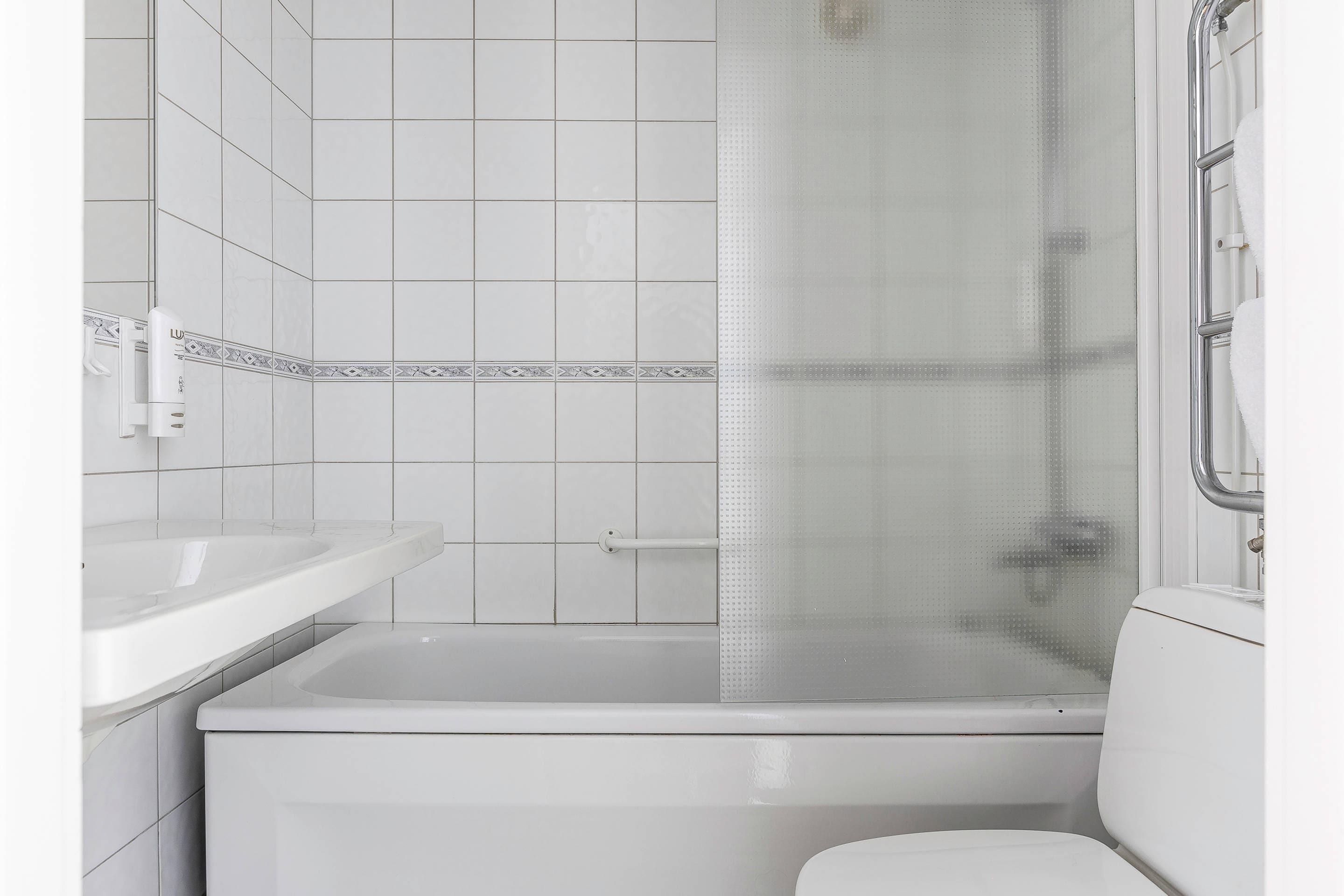 A bathroom with a bathtub, a toilet, and a sink.