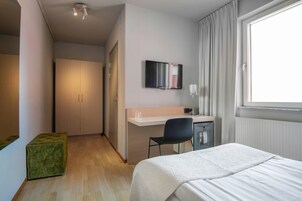 Escritorio, tabla de planchar con plancha y ropa de cama 