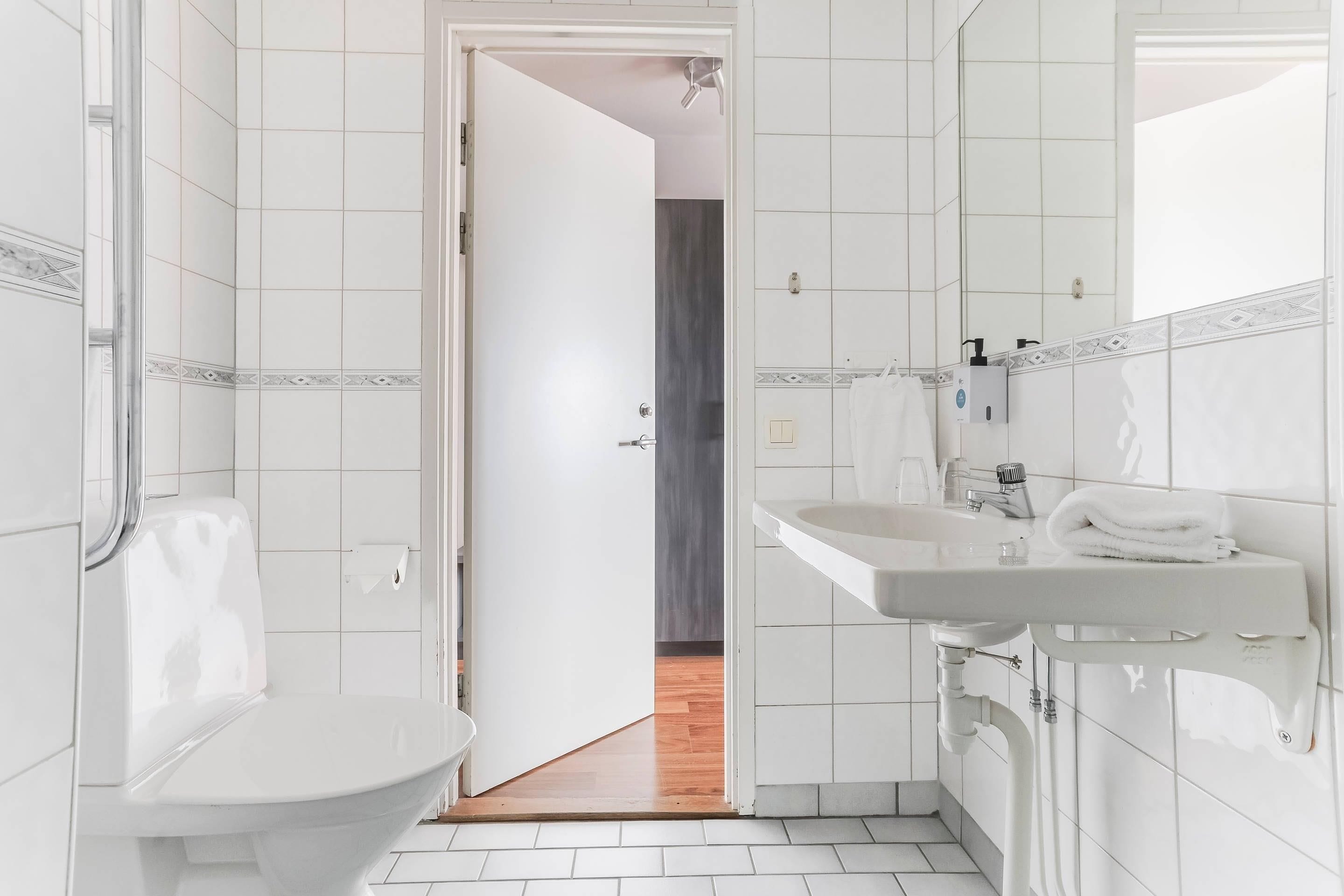 A modern bathroom with a toilet, sink, and shower area.