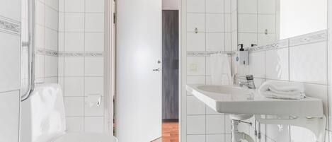 A modern bathroom with a toilet, sink, and shower area.