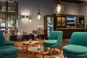 A modern lounge area with teal chairs, a glass coffee table, and pendant lighting. - Quality Hotel Sundsvall (Sundsvall)
