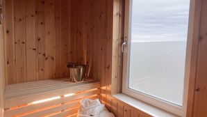A wooden sauna with a bench, a window, and a towel on the floor. - Best Western Hotel Halland (Kungsbacka)