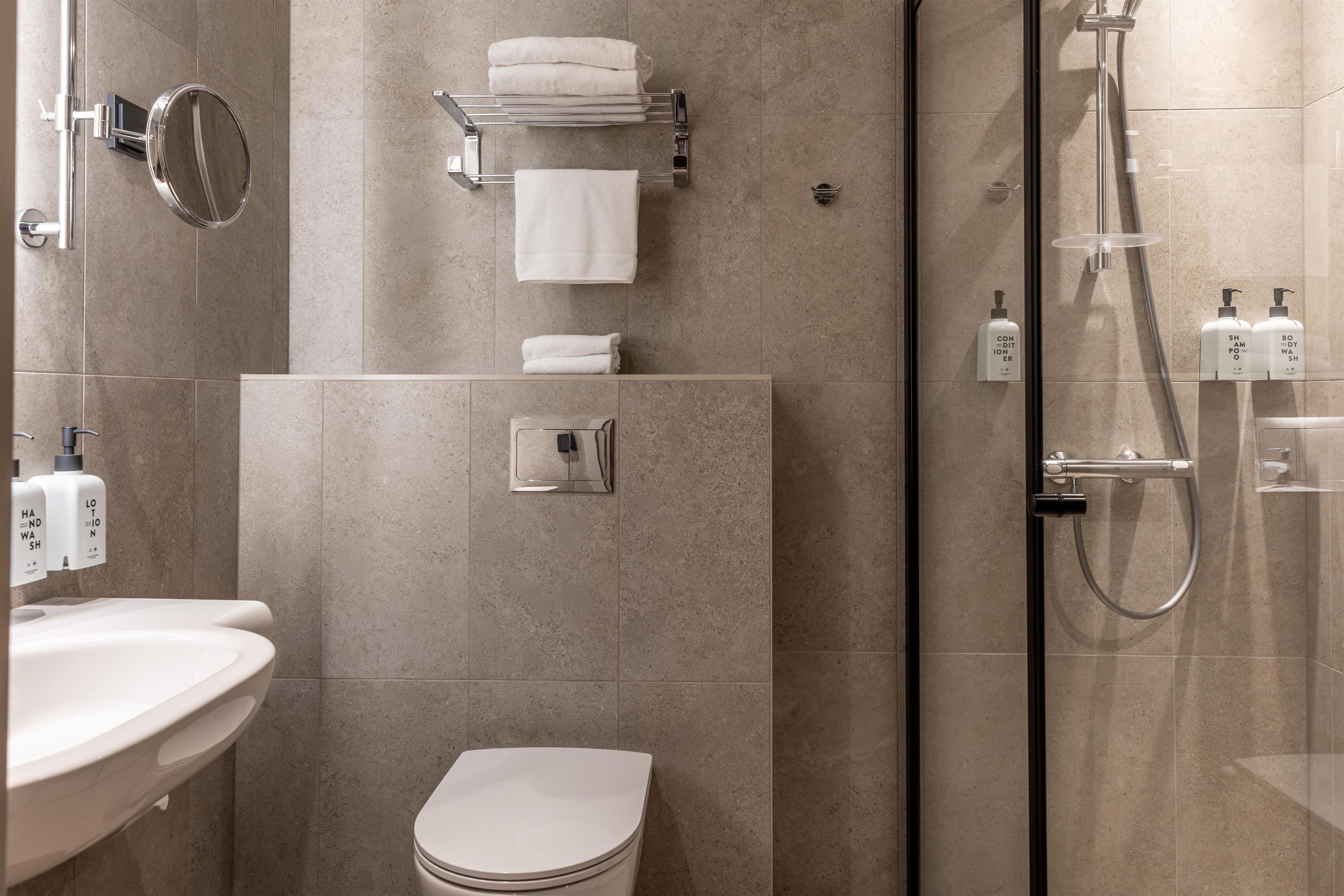 A modern bathroom with a toilet, sink, and shower area.