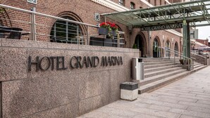 A hotel entrance with a stone wall, steps, and a covered walkway. - Scandic Grand Marina (Helsinki)