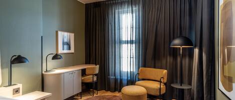 Una habitación de hotel con cama, escritorio, silla y dos lámparas de pie.