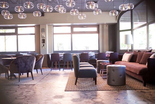 A modern interior with a dining area, seating, and large windows.
