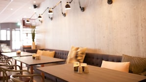 A restaurant interior with tables, chairs, and a sofa. - Scandic Winn (Karlstad)