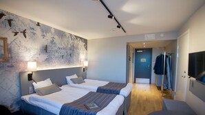 A hotel room with two beds, a large wall mural, a desk, and a chair. - Scandic Winn (Karlstad)