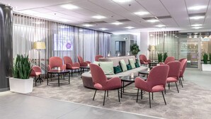 Ein stilvoller Lounge-Bereich mit einer Couch, mehreren Sesseln und einem Couchtisch.