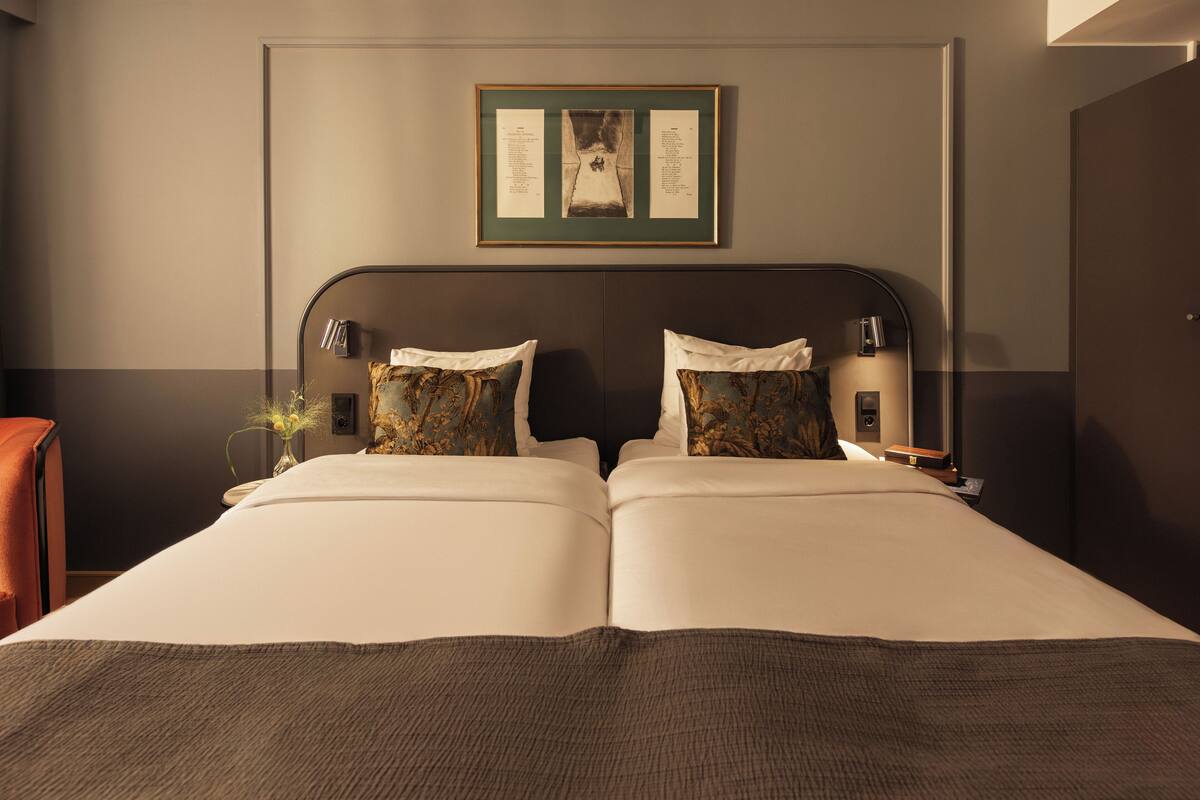 A double bed with a dark headboard, two bedside tables with lamps, and a framed picture above the bed.