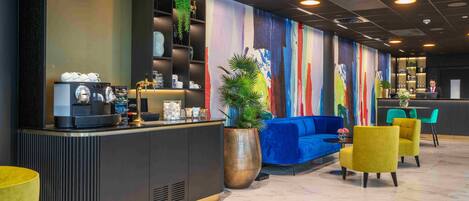 A modern reception area with a counter, seating, and a colorful mural.