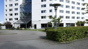A modern building with a glass entrance and multiple windows. The building has a sign that reads "Scandic". - Scandic Aarhus Vest (Aarhus)