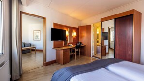 A hotel room with a bed, a desk, a television, and a mirror. - Scandic Aarhus Vest (Aarhus)