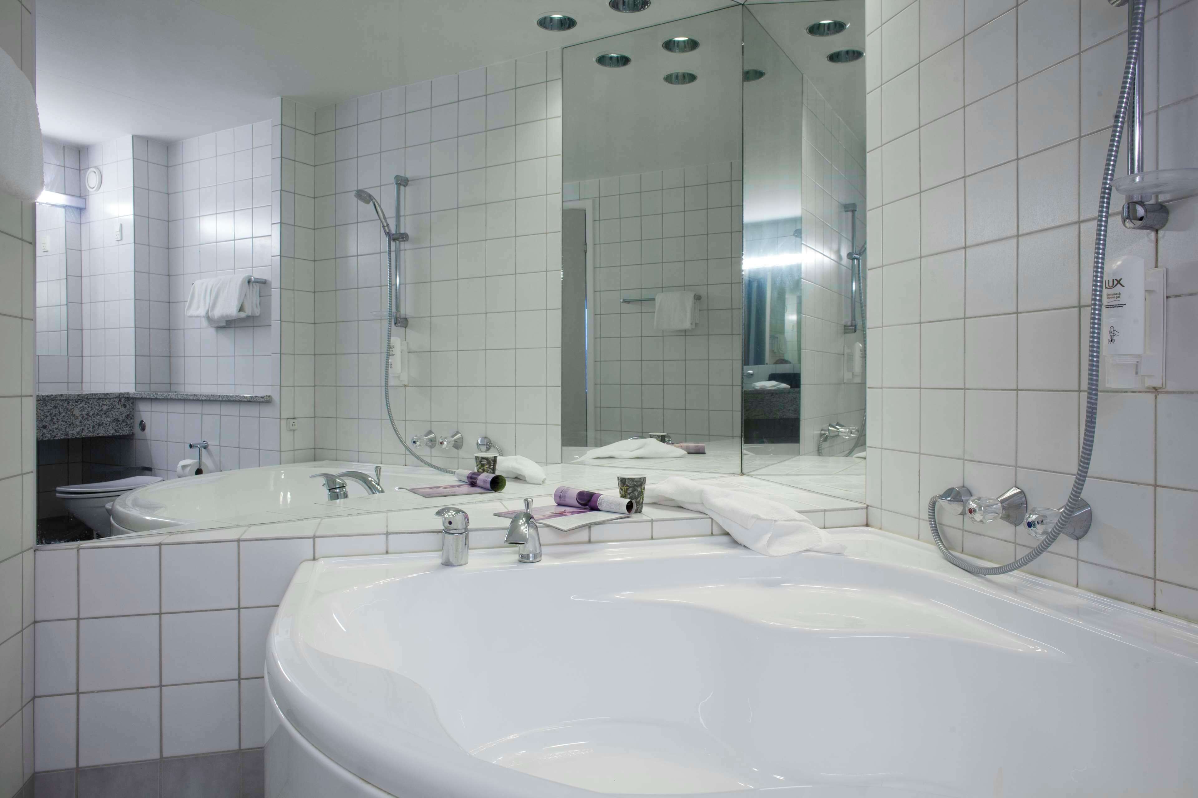 Un baño moderno con una bañera grande, lavamanos doble y cabina de ducha a pie.