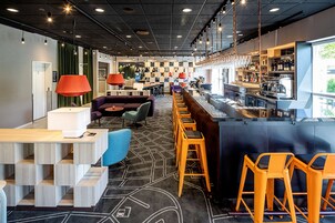 A modern bar area with a bar counter, stools, and seating.