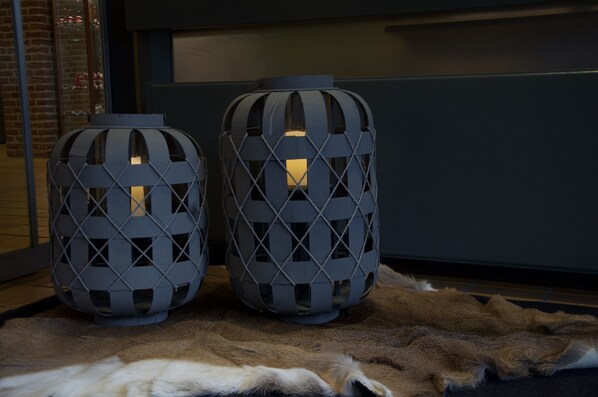 Two geometric-patterned lanterns on a fur rug.