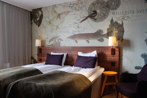 A hotel room with a large bed, two bedside tables, a chair, and a wall mural depicting a map and a fish. - Scandic Sundsvall Nord (Sundsvall)
