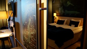 Une chambre d’hôtel avec un lit, un bureau et une carte de la Finlande accrochée au mur.