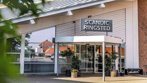 Entrada de un edificio con un letrero que dice 'SCANDIC RINGSTED'.