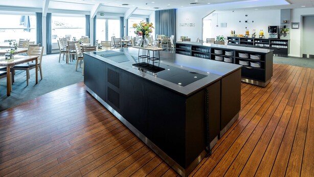 A modern hotel lobby with a central island, seating area, and a coffee station. - Scandic Odense (Odense)