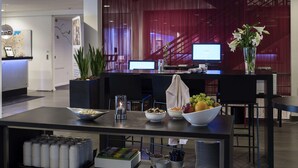 A modern reception area with a reception desk, computer monitors, and a fruit bowl. - Scandic Odense (Odense)