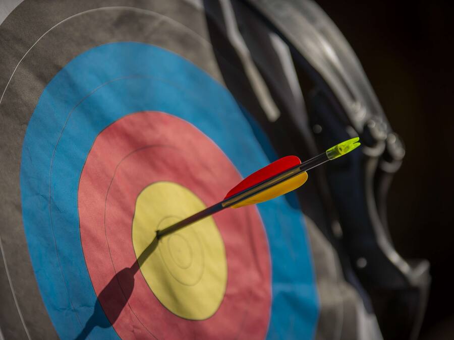 A dartboard with a dart in the center of the bullseye.