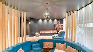 Una sala de estar moderna con un sofá modular azul, una chimenea y una lámpara colgante.