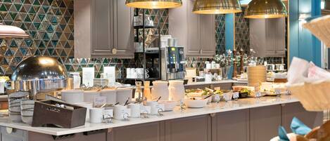A buffet setup with multiple serving stations, a coffee machine, and a variety of food items.