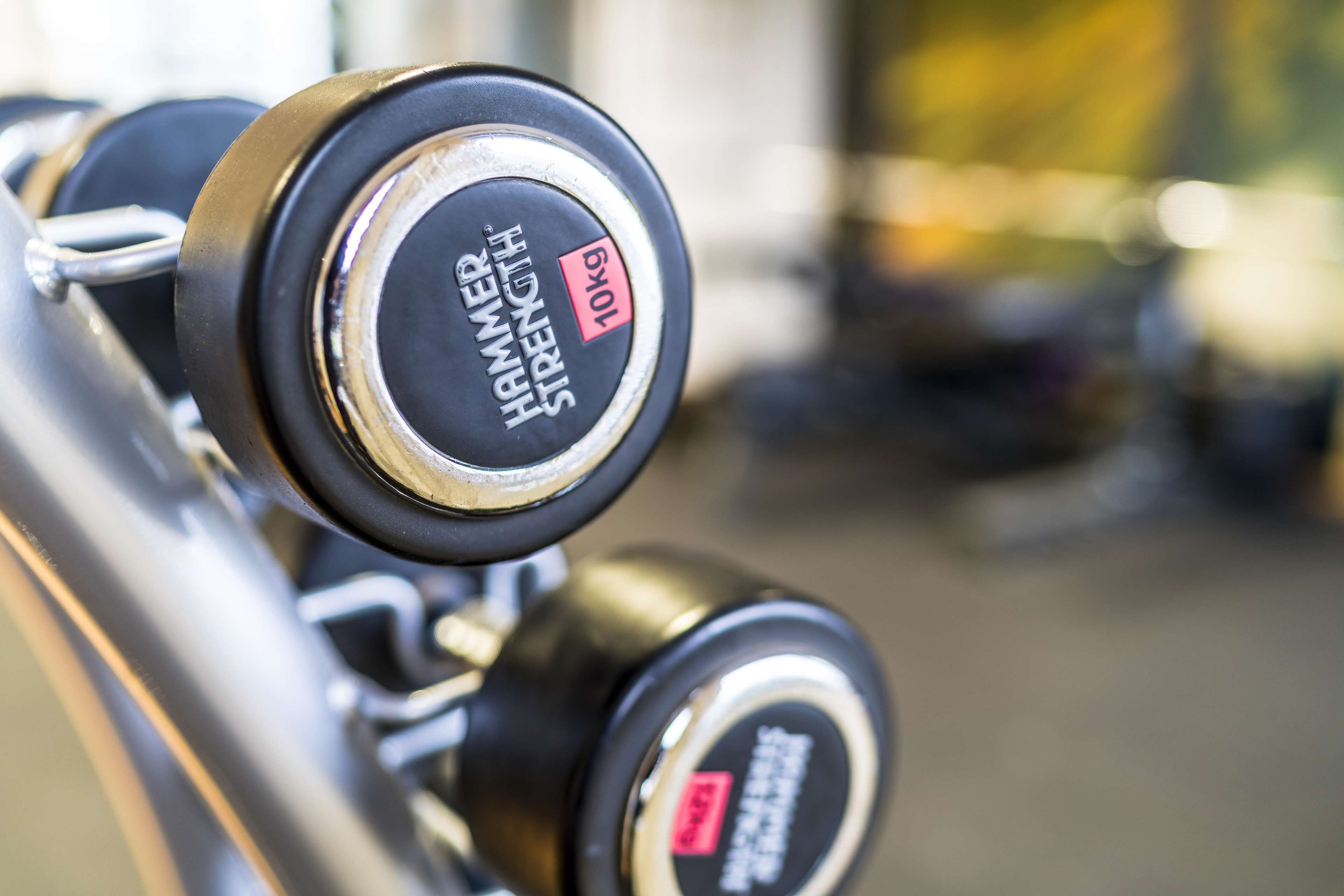 A close-up of a dumbbell with the label "Hammer Strength 10kg".