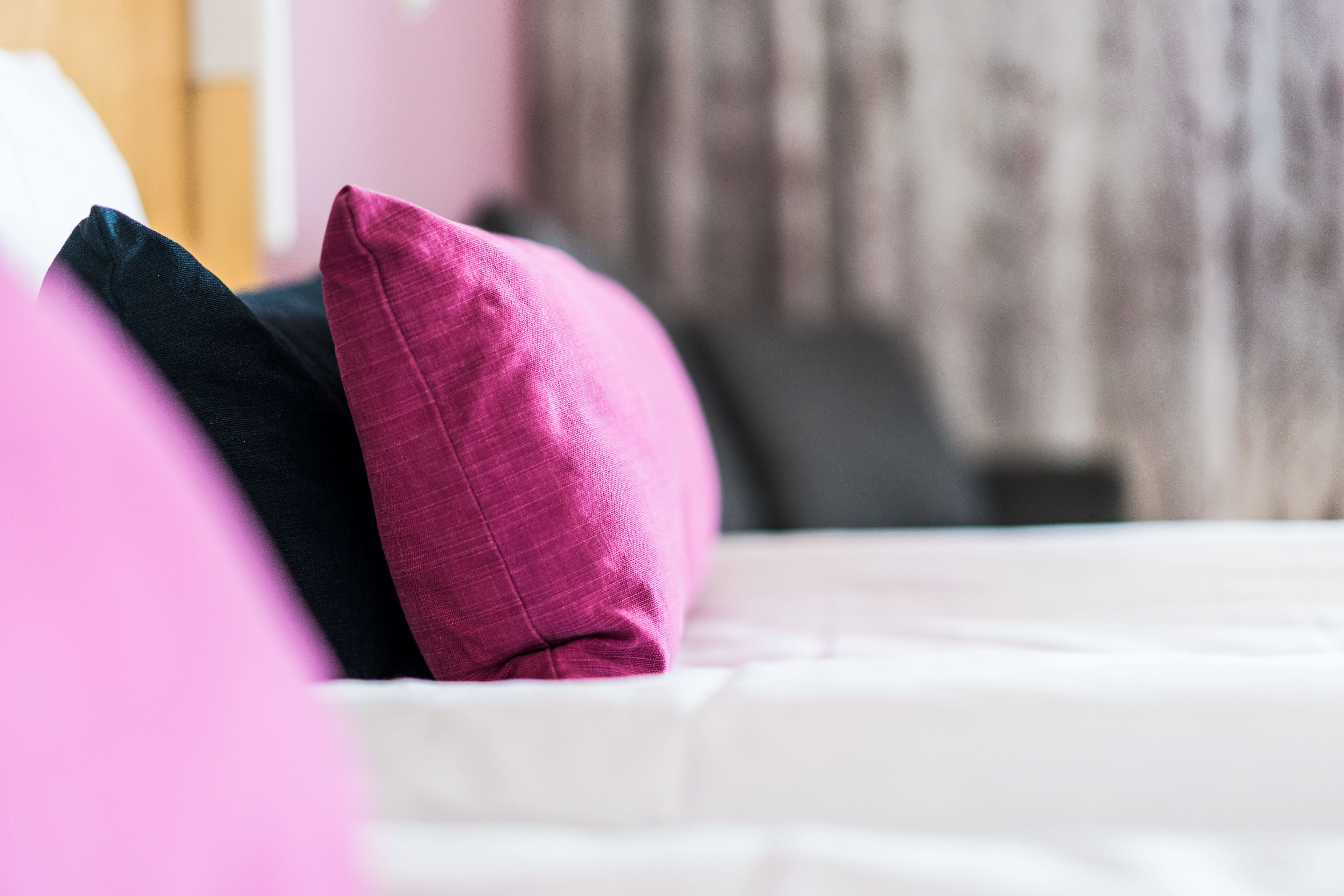A bed with pillows in a hotel room.
