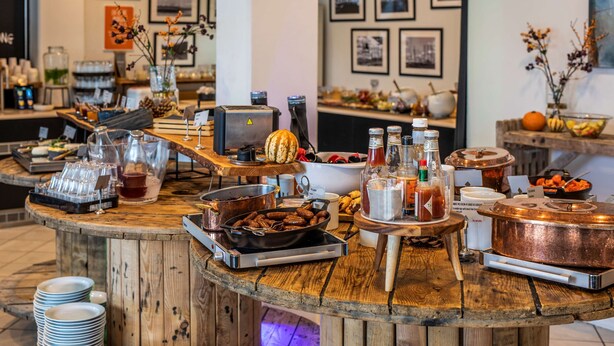 A buffet setup with various food items, cooking equipment, and condiments. - Scandic Olympic (Esbjerg)