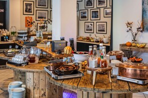 A buffet setup with various food items, cooking equipment, and condiments. - Scandic Olympic (Esbjerg)