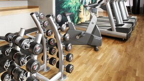 A gym with treadmills, elliptical machines, and a rack of dumbbells. - Scandic Backadal (Hisings Backa)