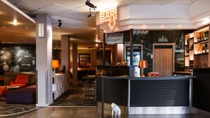 A modern bar area with a neon sign, seating, and a small dog near the counter. - Scandic Backadal (Hisings Backa)