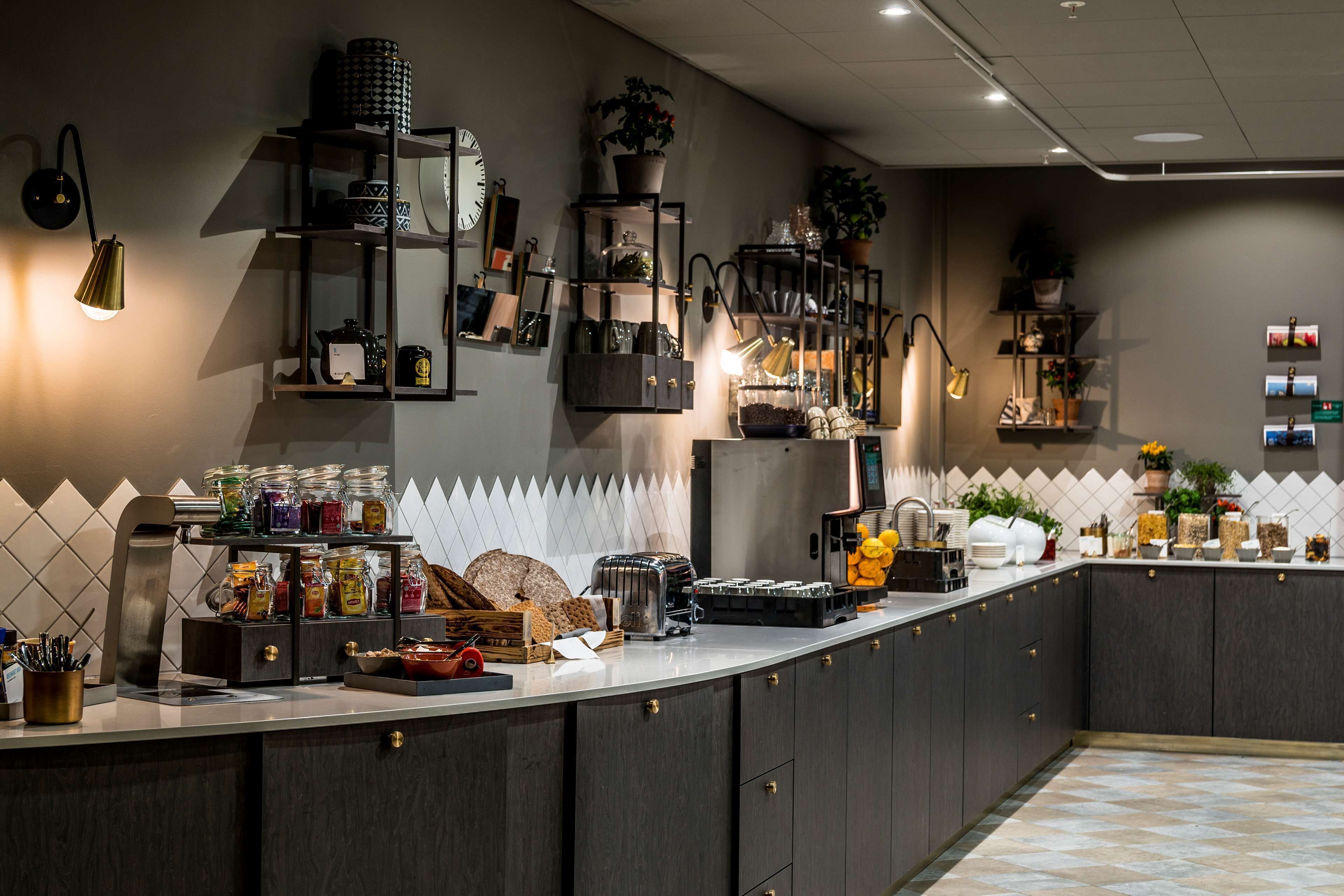 A modern kitchen with a long counter, built-in shelves, and various kitchen appliances.
