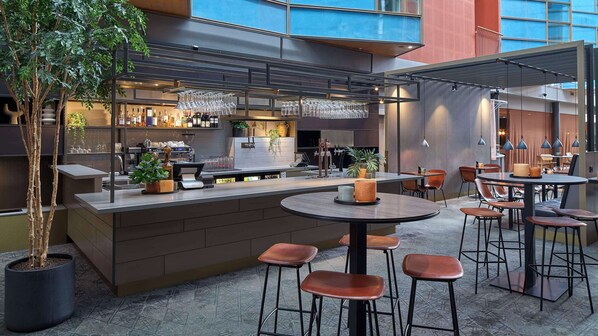 An outdoor bar area with seating, a counter, and a coffee machine.