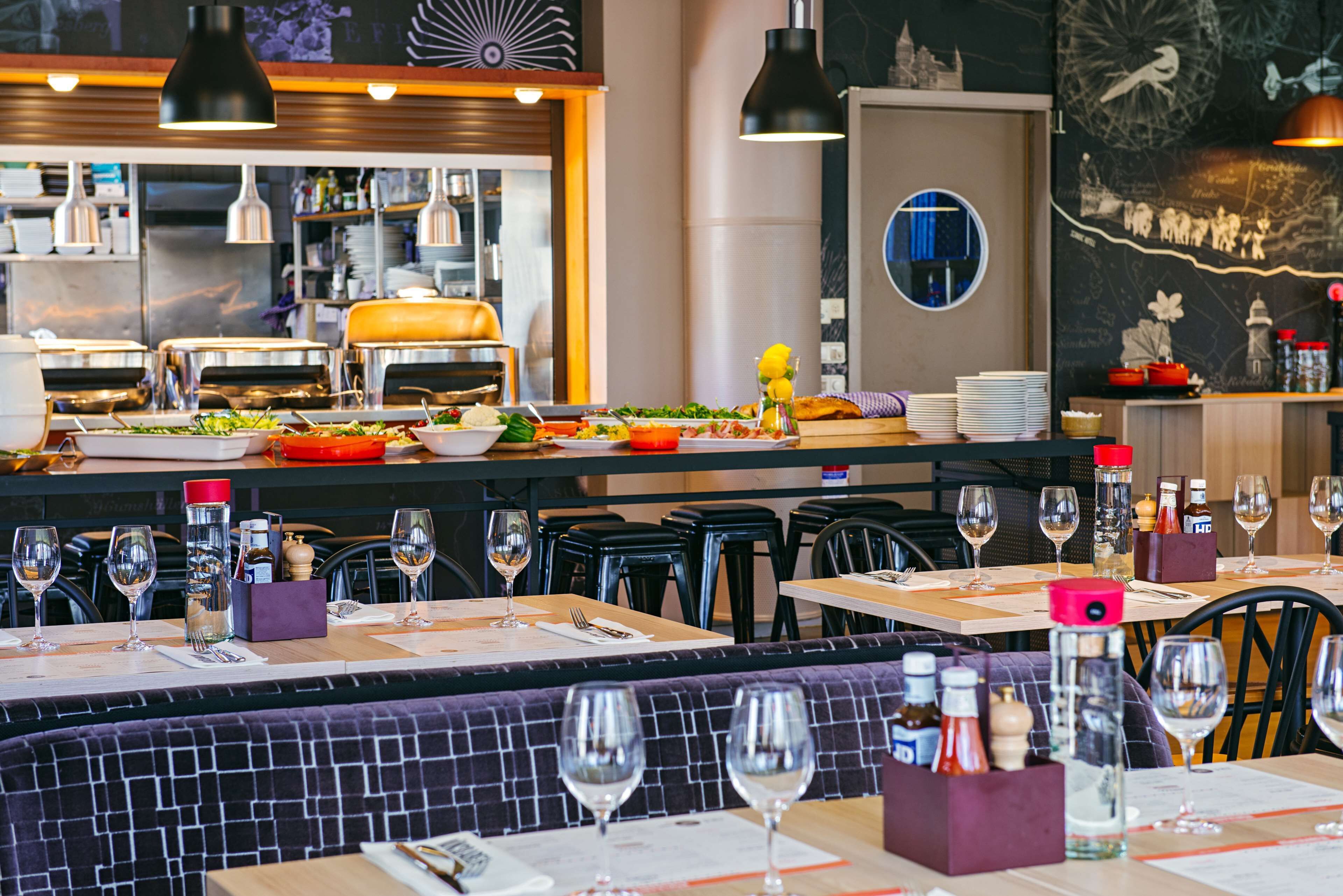 Un restaurant amb zona de bar, taules i caires.