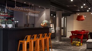 A bar area with stools, a counter, and a red toy car. - Scandic Södertälje (Sodertalje)