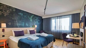A hotel room with two beds, a desk, a chair, a window with curtains, and a wall mural. - Scandic Södertälje (Sodertalje)