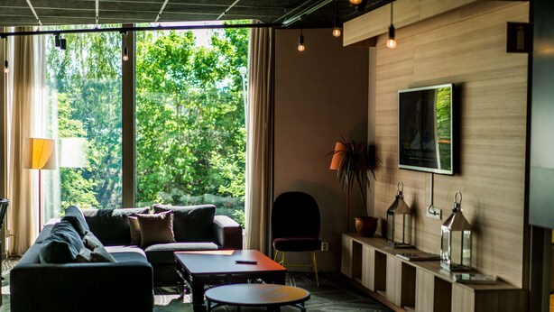 A modern living room with a sofa, a coffee table, and a TV mounted on the wall.