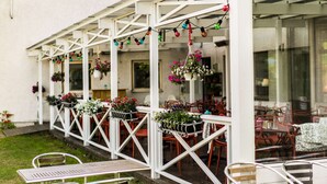 An outdoor patio area with white railings, tables, and chairs.