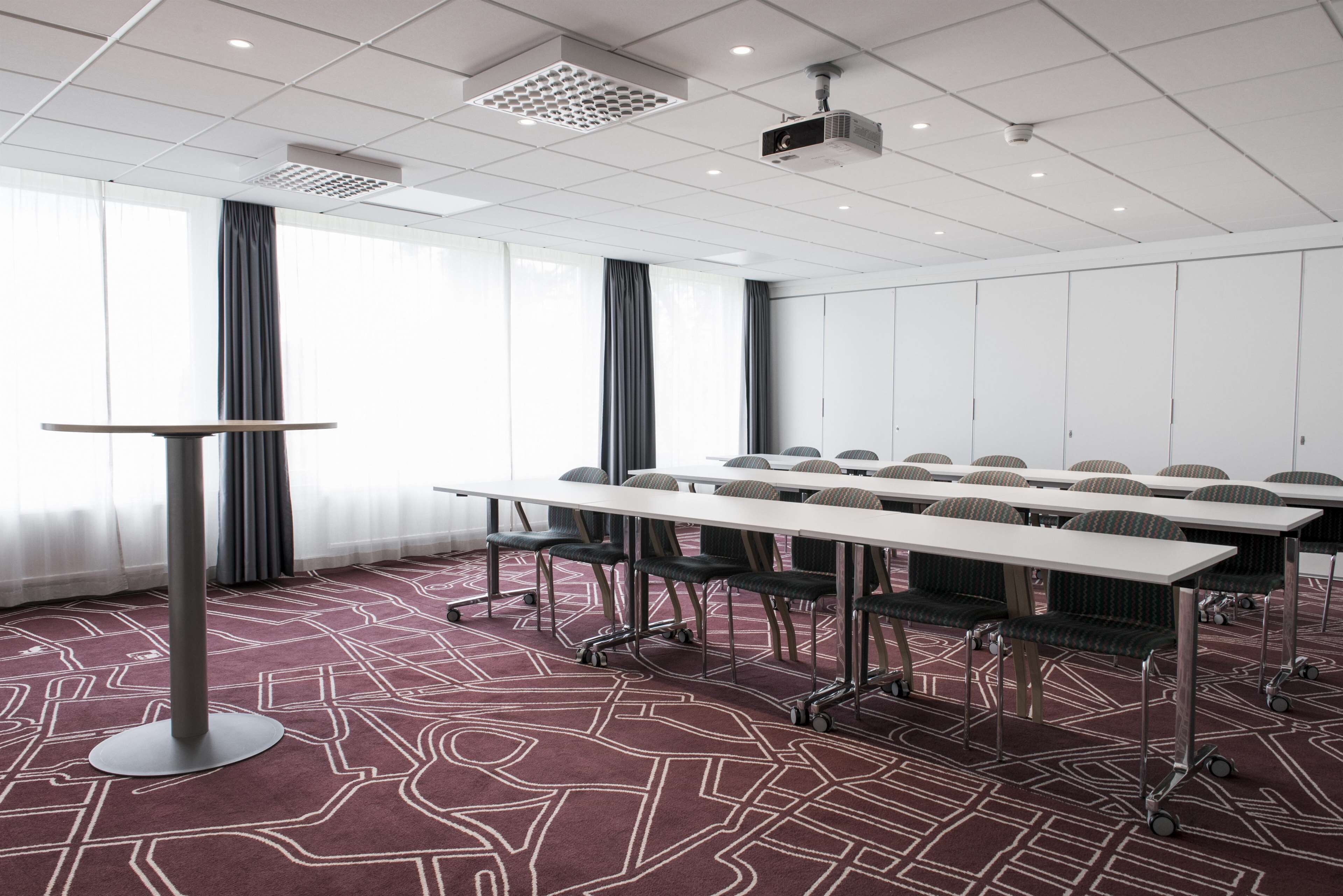 A conference room with a long table, chairs, and a projector.